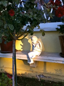 Garden cherub positioned in garden to catch the sunlight