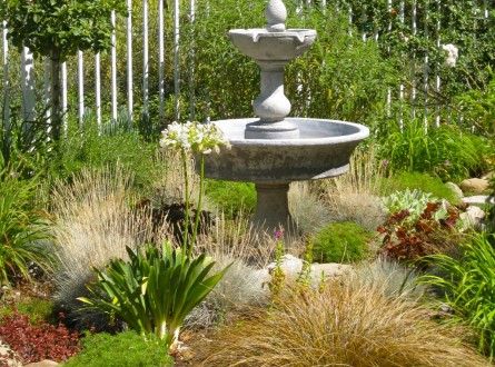 Ornamental grasses surround a two-tiered fountain